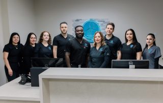 Shows physical therapists, chiropractors, and office staff posing for a group photo at the Body Wellness Center office in Northern NJ.